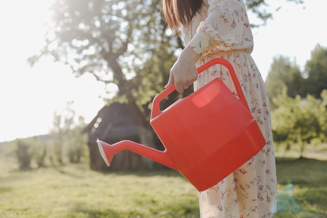 Photo by Galina Kondratenko a person carrying a red watering can as part of her daily movement